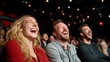 © svastix - Three friends, two men and a woman, laugh together in a theater setting. Their expressions show happiness and camaraderie, highlighting a joyful shared experience.
