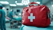 © svastix - A red emergency medical kit with a white cross prominently displayed in a hospital surgery room, symbolizing preparedness and readiness for medical situations.
