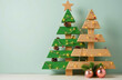© Arttali_Neuro - Two creative handmade wooden pallet Christmas trees, one green and one natural, are decorated with string lights, pinecones, and festive ornaments. Concept of DIY, eco-friendly holiday decor