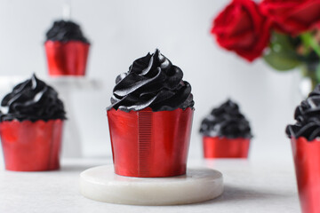 Sticker - red cupcakes with black buttercream swirl, cupcakes in red foil liners with black buttercream, frosted Halloween valentines cupcakes on a white background