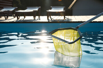 Sticker - Cleaning swimming pool with skimmer net on sunny day