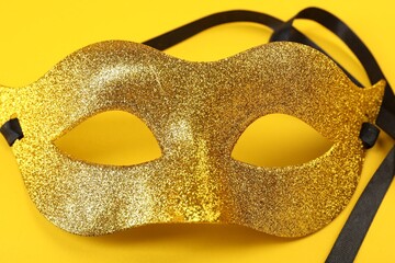 Poster - One golden carnival mask on yellow background, closeup