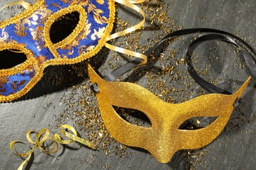 Poster - Beautiful carnival masks and confetti on gray textured table, flat lay