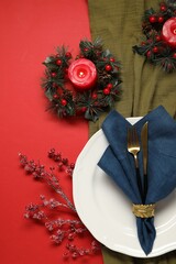 Poster - Christmas place setting with festive decor on red table, flat lay