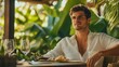© Scott - A handsome young individual sitting comfortably at a luxurious outdoor dining table, with lush greenery in the background.