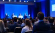 © Sebelas Studio - Audience at a conference listening to speakers on a stage.