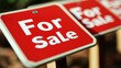 © aicandy - Three red For Sale signs displayed on wooden posts in a row, focusing on the first sign with blurred background, indicating property availability for purchase
