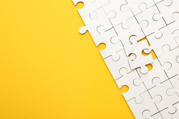 Sticker - White puzzle pieces on yellow background, top view. Space for text