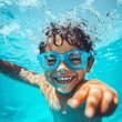 © VISUAL BACKGROUND - A young boy wearing swimming goggles in a swimming pool