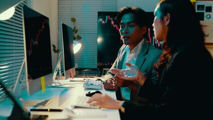 Poster - Two stockbrokers engage in a discussion while reviewing stock market data on a computer screen in their office, analyzing charts and graphs to develop investment strategies