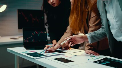Poster - Team of business professionals are working late, collaborating on a project. They're deeply engaged in analyzing financial charts and market trends