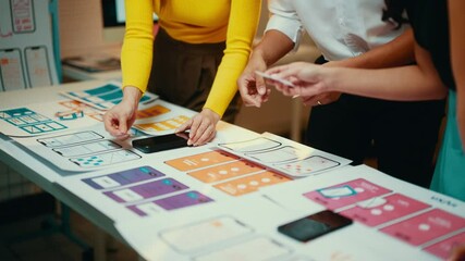 Aufkleber - Designers review a mobile application design, arranging screens on a table for discussion. Collaboration fosters creativity and innovation in the development process