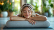 © Pui - A woman relaxing with her hands resting on a yoga bolster, A serene woman practicing relaxation techniques in a peaceful environment, emphasizing mindfulness and inner tranquility.