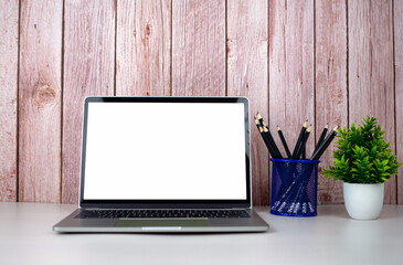 Poster - Laptop with blank screen on white table and office supplies on wooden background. Space for copying your text. Workspace and copy space. Desk with office supplies.