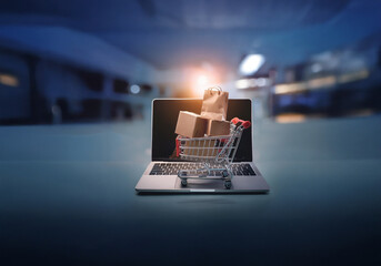 Poster - A miniature shopping cart filled with cardboard boxes and a paper bag sits on top of a laptop keyboard.
