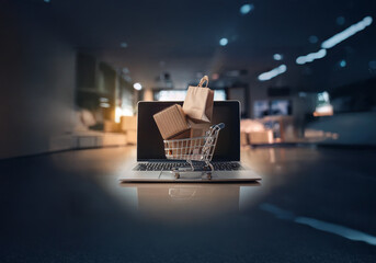 Poster - A miniature shopping cart is placed on a laptop keyboard with a brown paper bag and cardboard boxes inside.