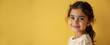 © Natalia - Smiling young Arab girl with long hair facing sideways against bright yellow background, copy space