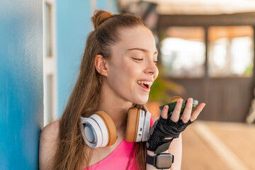 Wall Mural - Young pretty sport girl at outdoors holding an avocado