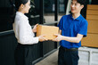 © Nuttapong punna - Express Delivery Service. Asian Courier Delivering Package to man Delivery service near van outside the warehouse, delivery home
