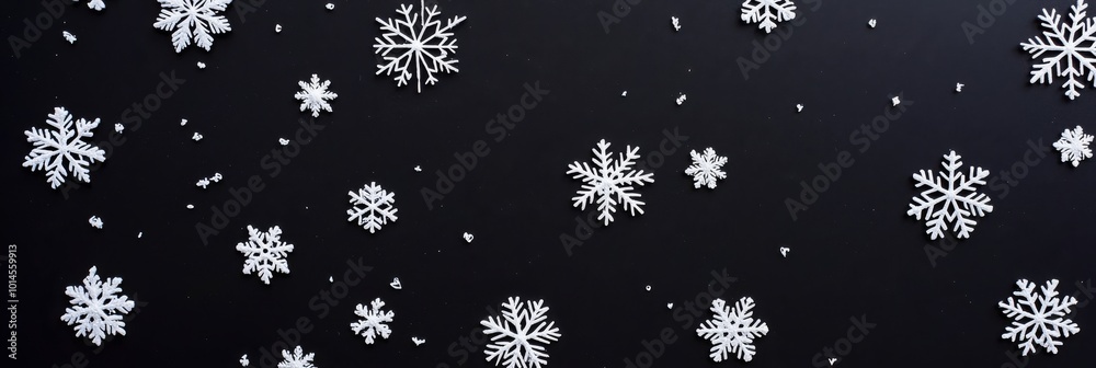 A few white snowflakes float on a plain black background. These snowflakes vary in size and shape to create a soft and delicate winter atmosphere, adding a touch of elegance and simplicity.