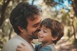 © Ahmed - Father bonding kiss and boy child hug happy in nature with quality time together outdoor Happiness laughing and family love of a dad and kid in a park enjoying nature hugging with care and a smile