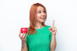 © luismolinero - Young Russian girl with an apple isolated on white background intending to realizes the solution while lifting a finger up