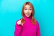 © luismolinero - Young Russian woman isolated on blue background surprised and pointing front