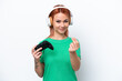 © luismolinero - Young Russian girl playing with a video game controller isolated on white background making money gesture