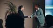 © peopleimages.com - Business women, handshake and smile for prize, congratulations or meeting on event stage. Celebration, shaking hands and introduction for conference, award or interview for tradeshow presentation