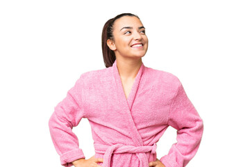 Wall Mural - Young woman in a bathrobe over isolated chroma key background posing with arms at hip and smiling