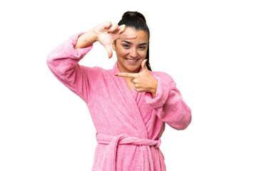 Wall Mural - Young woman in a bathrobe over isolated chroma key background focusing face. Framing symbol