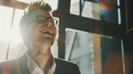 Sticker - A man with glasses laughs heartily, illuminated by sunlight streaming through a window, creating a warm, joyful atmosphere.