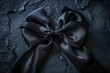 © Alena - A simple black bow tied to a black background, ideal for use in designs where you want to draw attention to something or add a touch of elegance