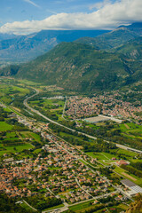 Panoramic landscape of the Italian city, photos from a drone, quadcopter, aerial photography. The city, the houses with tiled roofs, the road and the mountains. Layout. A miniature. View of Piedmont, 