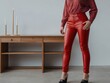 © shrinay - crop view Unrecognizable model wearing red leather pants. AI Generative