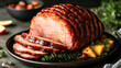 © Kowit - A large piece of ham is cut into slices and served on a black plate