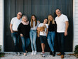 © Austockphoto - Multigenerational family standing outside in front of black garage door