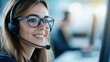 © BoOm - Smiling woman with headset, engaging in customer service, modern office environment.