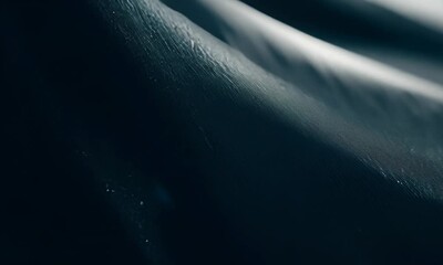 Wall Mural - close up shot of a dark textured fabric with a hint of light reflecting off the surface.