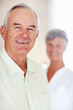 © STEEXBuyout/peopleimages.com - Home, senior man and smile in portrait for retirement, memory and laughing with positive attitude. Elderly couple, male person and old woman in marriage for commitment, connection and happy in house