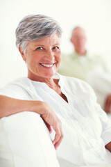 Poster - Elderly woman, sofa and smile for retirement, confident and relax on weekend in home with good health. Senior person, portrait and happy for comfort, peace or break in living room with positive mood