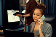 © Summit Art Creations - Businesswoman calling with customers to make new project job at modern office while coworker checking paperwork folder of business plan to database report meeting at over late night time. Infobahn.
