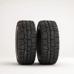 Two off-road tires with deep treads on a white isolated background.