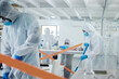 © peopleimages.com - People, disinfection or investigation team with hazmat suit for cleaning, health and safety in laboratory. Scientists, group or biohazard squad sanitizing workspace or lab for hygiene or sanitation