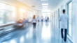© watz - Blurred motion of people walking through a hospital corridor, emphasizing the movement and bright lighting.