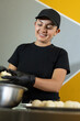 © Andrey - beautiful baker woman smiles as she shapes the dough for bunuelos or cheese breads eaten at Christmas time