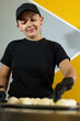 © Andrey - smiling woman arranges the dough for the bunuelos or cheese breads on the tray to be fried