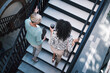 © HockleyM4/peopleimages.com - Walking, chat and business people on stairs with coffee, planning and morning travel to real estate office. Realtor, women and professional friends on steps with talk, drink and commute from above
