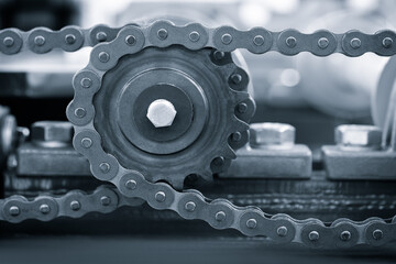 Aufkleber - A chain with a gear on it. The chain is made of metal and has many small metal pieces on it, industrial concept background