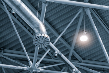 Poster - A light is shining on a metal structure with a camera on it. The structure is a ventilation system